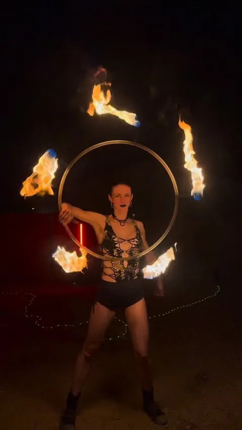 Fire hoop and fire fans burning at night
