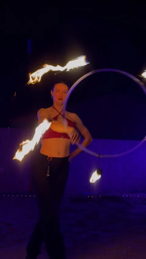 Fire hoop and fire fans performed on the playa at night