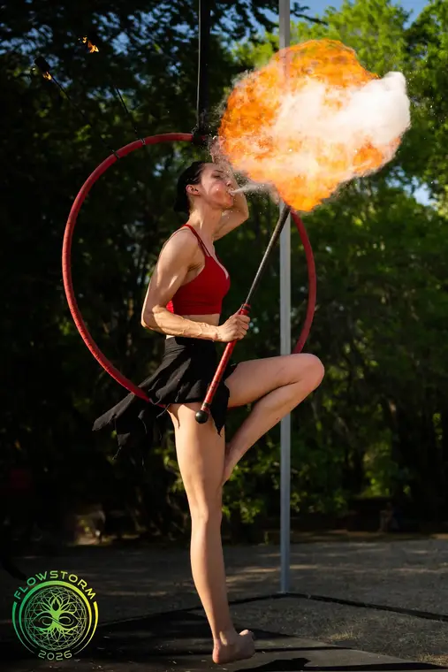 Fire breathing while hanging from an aerial hoop