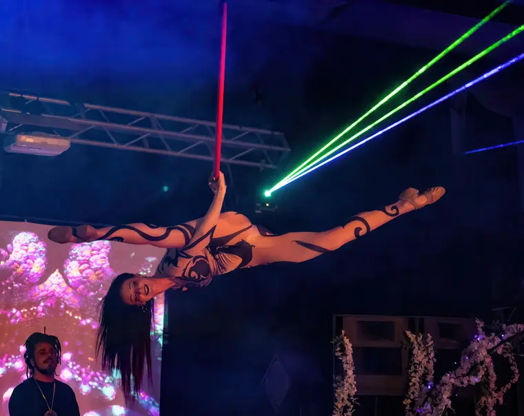 Alien costumed split in the aerial hoop at Art Explosion