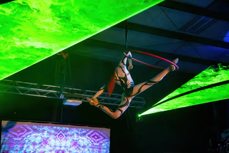 Elbow hang in the aerial hoop under green light