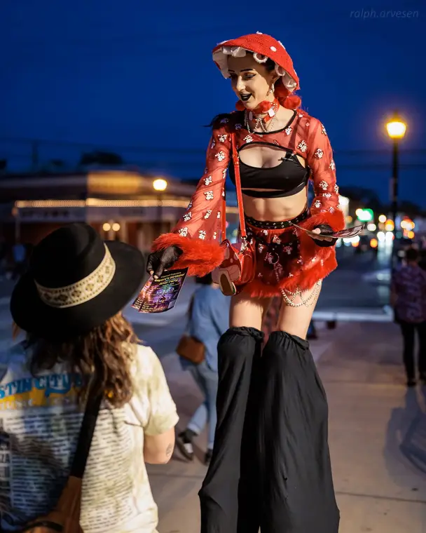 Mushroom stilt character with a crowd
